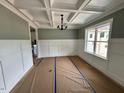 Elegant dining room with coffered ceiling, modern chandelier, and stylish wall paneling at 27 Batten Hill Ln, Selma, NC 27576