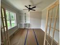 Bright office with built-in bookshelves, ceiling fan, and large windows for natural light at 27 Batten Hill Ln, Selma, NC 27576