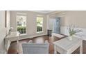 Bright living room with hardwood floors, neutral paint, modern furniture, and large windows offering a view of the front yard at 3302 Colorcott St, Raleigh, NC 27614