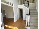 Open foyer with hardwood floors, staircase, and access to other rooms at 3316 Belspring Ln, Raleigh, NC 27612