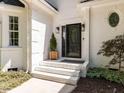 Inviting front entrance with an ornate door, stylish lighting, and well-kept landscaping at 3332 Langston Cir, Apex, NC 27539