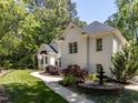 Beautiful white brick home surrounded by mature trees and a decorative fountain at 3332 Langston Cir, Apex, NC 27539
