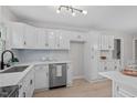 Bright kitchen with white cabinets, stainless steel appliances and wood flooring at 3408 Brentwood Rd, Raleigh, NC 27604