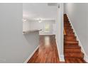 Warm entryway featuring hardwood floors, a staircase, and a glimpse into the living area at 4000 Volkswalk Pl, Raleigh, NC 27610