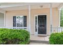 Inviting front porch with classic black door, white trim, and manicured shrubs at 4000 Volkswalk Pl, Raleigh, NC 27610