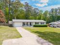 Charming single story house with attached garage, front yard, and mature trees in background at 4908 Vallery Pl, Raleigh, NC 27604