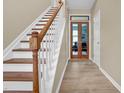 Elegant staircase with hardwood treads, white risers, and stylish wood doors leading to other rooms at 503 Bellefont Ct, Knightdale, NC 27545