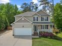 Inviting home with a two-car garage, manicured lawn, and a charming front porch at 503 Mugo Pine Ct, Wendell, NC 27591