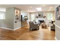 Cozy living area featuring a brick fireplace, skylight, hardwood floors, and neutral decor at 508 Colony Woods Dr, Chapel Hill, NC 27517