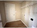 Practical laundry room featuring hardwood floors and ample space for appliances and storage at 56 Ruskin Dr, Smithfield, NC 27577