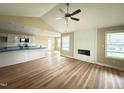 Bright living room with a fireplace, hardwood floors, and a view of the kitchen at 56 Ruskin Dr, Smithfield, NC 27577