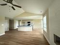 Open living area with a fireplace, ceiling fan, and hardwood floors with a view of the kitchen at 56 Ruskin Dr, Smithfield, NC 27577