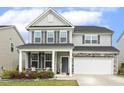 Charming two-story home with a welcoming front porch, gray siding, and stone accents at 575 Dawley Dr, Fuquay Varina, NC 27526