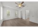 Bright bedroom with hardwood floors, ceiling fan, and two windows at 620 Hanska Way, Raleigh, NC 27610