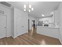Open dining area featuring hardwood floors, modern chandelier, and access to the kitchen at 633 Prickly Pear Dr, Fuquay Varina, NC 27526
