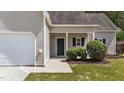 Front door with landscaped bushes, with an attached garage and a small overhang at 633 Prickly Pear Dr, Fuquay Varina, NC 27526
