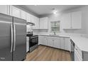 Well-lit kitchen with stainless steel appliances, white cabinetry, and a modern design at 633 Prickly Pear Dr, Fuquay Varina, NC 27526