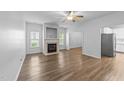 Bright living room featuring a fireplace, hardwood floors, and ample natural light at 633 Prickly Pear Dr, Fuquay Varina, NC 27526