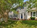 Charming home featuring a patriotic display with an American flag and blue shutters enhancing the curb appeal at 6718 Twin Tree Ct, Raleigh, NC 27613