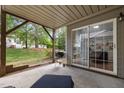 View of a covered patio with a grill and sliding glass doors, leading to outdoor living at 703 Kirkeenan Cir, Morrisville, NC 27560