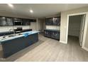 Modern kitchen featuring dark cabinetry, stainless steel appliances, and a central island with a sink at 72 Ruskin Dr, Smithfield, NC 27577