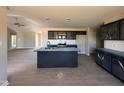 Modern kitchen with an island, stainless steel appliances, gray cabinets and countertops, and a view to the living room at 72 Ruskin Dr, Smithfield, NC 27577