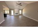 Bright living room featuring an electric fireplace, ceiling fan, wood floors, and many windows for natural lighting at 72 Ruskin Dr, Smithfield, NC 27577
