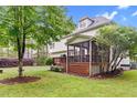 A beautiful backyard view with a wooden screened porch extending from the house at 7321 Clarincarde Ct, Wake Forest, NC 27587