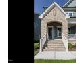 Inviting entryway with brick archway, white railings, and a cozy porch area, offering curb appeal at 737 W Holly Springs Rd, Holly Springs, NC 27540