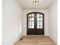 The bright foyer features an arched glass double-door entry and light wood flooring at 749 W Holly Springs Rd, Holly Springs, NC 27540