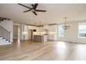 The open kitchen is complete with an island, modern lighting, stainless appliances, and ample counter space at 749 W Holly Springs Rd, Holly Springs, NC 27540