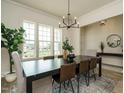 Spacious dining area with a large window, modern chandelier, and stylish table setting at 755 W Holly Springs Rd, Holly Springs, NC 27540