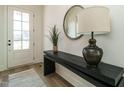 Inviting entryway featuring a stylish console table, round mirror, and a bright doorway at 755 W Holly Springs Rd, Holly Springs, NC 27540