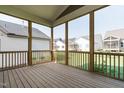 Enjoy outdoor living on this screened-in porch with wooden decking and views of neighboring homes at 761 W Holly Springs Rd, Holly Springs, NC 27540