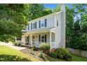 Two-story home with gray siding, black shutters, white porch and manicured landscaping at 8009 Tobin Pl, Raleigh, NC 27612
