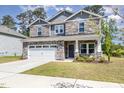 Two-story home with stone and gray siding and a two-car garage, providing an attractive curb appeal at 8013 Toddwick Ct, Raleigh, NC 27616