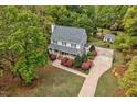 Aerial view showcasing a gray home with mature trees and a charming outdoor space with a shed at 817 S Creek Dr, Nashville, NC 27856