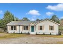 Charming one-story home featuring new shutters, a teal front door, and a gravel driveway at 8201 Rhodes Rd, Apex, NC 27539