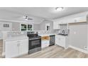 Well-lit kitchen features stainless steel appliances, white cabinets, and a stylish backsplash at 8201 Rhodes Rd, Apex, NC 27539