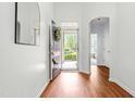 Welcoming entryway featuring gleaming wood floors, a stylish mirror, and a view of the front yard at 8525 Holdenby Trl, Raleigh, NC 27616