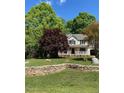 Traditional home with a welcoming front porch, set amidst mature trees and a stone retaining wall at 928 Broadhaven Dr, Raleigh, NC 27603