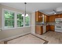 Eat-in kitchen with light wood cabinets, granite countertops and large windows overlooking the backyard at 928 Broadhaven Dr, Raleigh, NC 27603