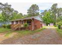 A cozy brick house is nestled among trees, offering a peaceful setting and a long driveway at 107 Glosson Cir, Carrboro, NC 27510