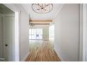 Bright hallway featuring hardwood floors, wooden beams, and an elegant chandelier at 1108 Delilia Ln, Wake Forest, NC 27587