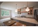 This kitchen features a large island, custom cabinetry, and modern lighting fixtures with hardwood floors at 1108 Delilia Ln, Wake Forest, NC 27587