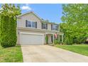 Inviting two-story home boasts a two-car garage, neat landscaping, and a welcoming front porch at 1307 Torrey Pines Ct, Mebane, NC 27302
