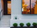 A stylish townhome entrance with light brick, black door and window frames, and tidy landscaping at 1308 Chamblee Hill Ct, Raleigh, NC 27608