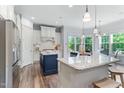 Gourmet kitchen boasts white cabinets, stainless steel appliances, an island, and a separate breakfast bar at 1308 Green Oaks Pkwy, Holly Springs, NC 27540