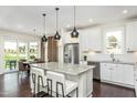 Modern kitchen with stainless steel appliances, center island and breakfast bar overlooking the dining area at 1606 Garden Park Cir, Fuquay Varina, NC 27526