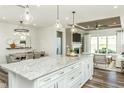 Open-concept kitchen island with pendant lighting, white cabinets, and granite countertops at 1614 Garden Park Cir, Fuquay Varina, NC 27526